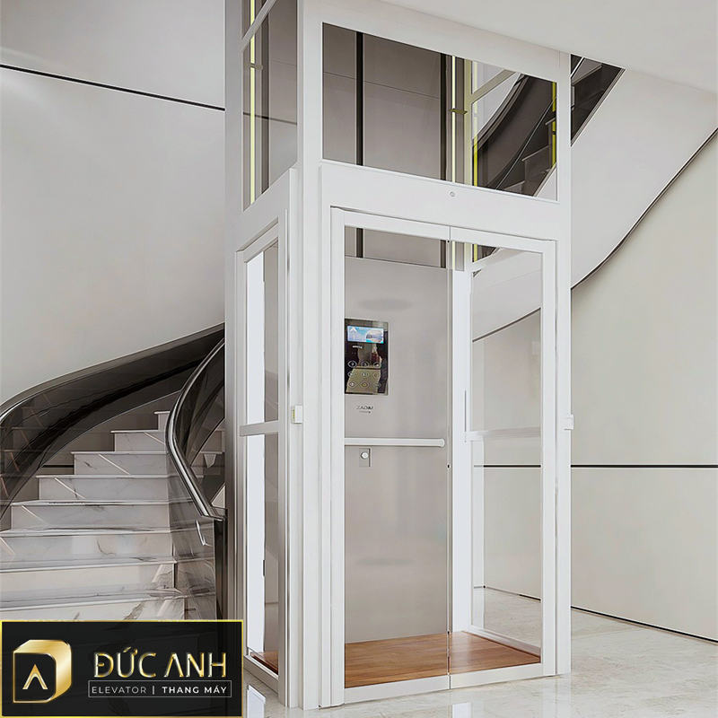 Thang máy kính được lắp đặt cạnh cầu thang bộ cũng khá phổ biến